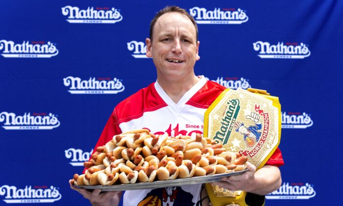 Competitive eater Joey Chestnut poses for photos with 76 hot dogs at a weigh-in before the Nathan's Famous July Fourth hot dog eating contest in New York on July 1, 2022. (Julia Nikhinson/AP Photo)