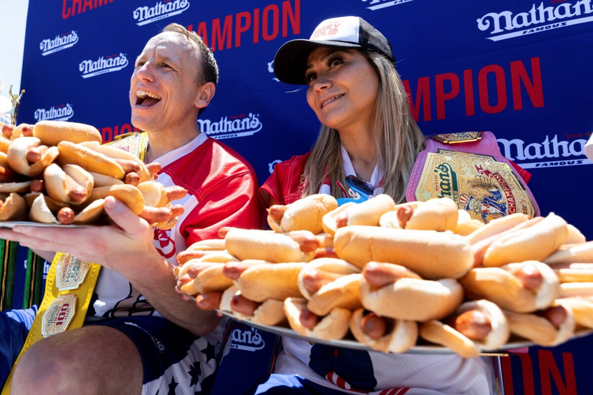 Joey Chestnut and Miki Sudo pose with 63 and 40 hot dogs