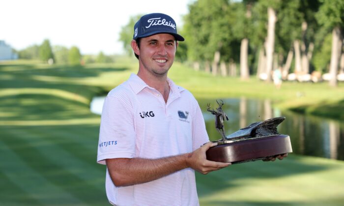 J.T. Poston of the United States poses with the trophy after putting in to win on the 18th green during the final round of the John Deere Classic at TPC Deere Run in Silvis, Ill., on July 3, 2022. (Stacy Revere/Getty Images)