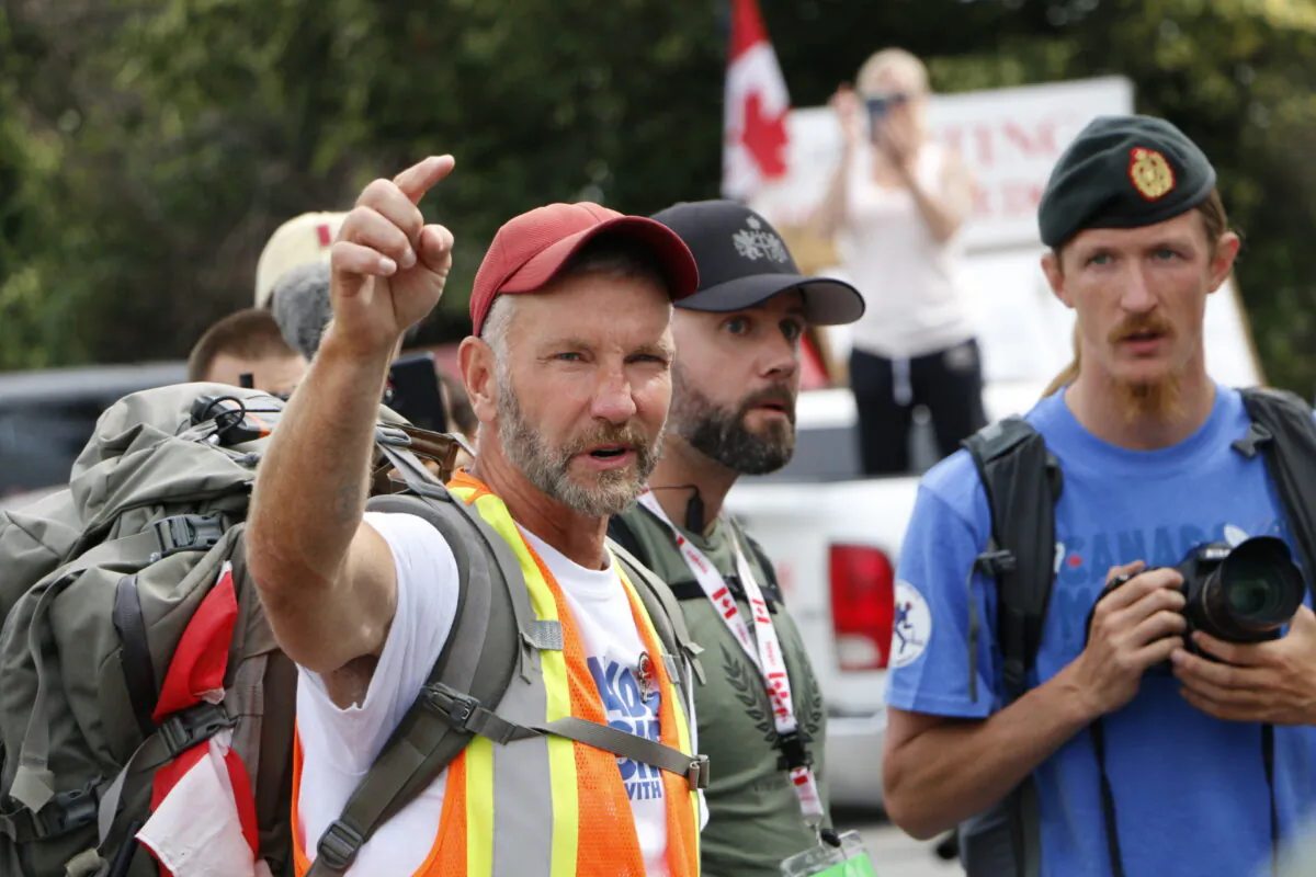 James Topp gives instructions to a group of supporters walking with him on the last day of his trek in Ottawa on June 30, 2022. (Noé Chartier/The Epoch TImes)