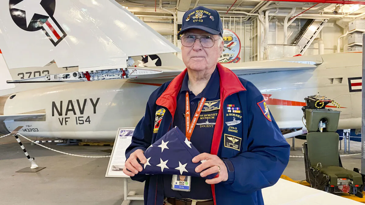 Richard Keefer holds a folded U.S. flag at the USS Hornet Museum in Alameda, Calif., on June 28, 2022. (Ilene Eng/NTD Television)