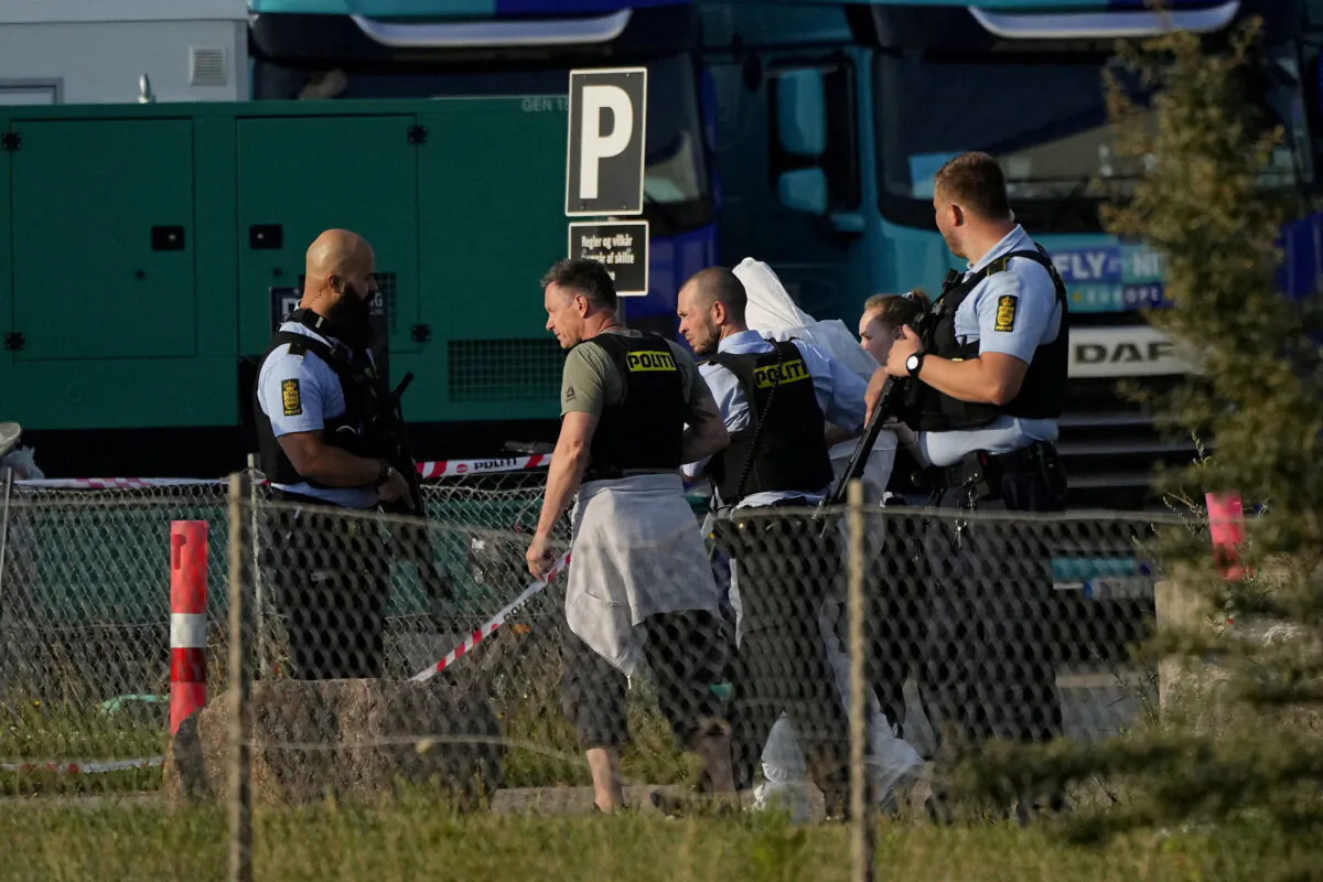Police officers take away a person wearing a white protective suit outside Field's shopping center, after Danish police said they received reports of a shooting at the site, in Copenhagen, Denmark, on July 3, 2022. (Ritzau Scanpix/Claus Bech  via Reuters)
