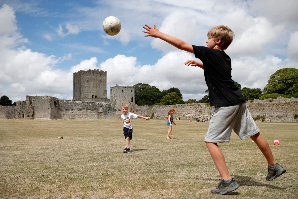 Children play football while visiting Portchester Castle, near Portsmouth, southern England, on Aug. 5, 2020. Originally built in the late 3rd century, Portchester Castle is the most impressive and best preserved of the Saxon shore forts. For medieval kings it was an important embarkation point for crossing the Channel. (Adrian Dennis/AFP via Getty Images)