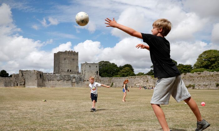 Children play football while visiting Portchester Castle, near Portsmouth, southern England, on Aug. 5, 2020. Originally built in the late 3rd century, Portchester Castle is the most impressive and best preserved of the Saxon shore forts. For medieval kings it was an important embarkation point for crossing the Channel. (Adrian Dennis/AFP via Getty Images)
