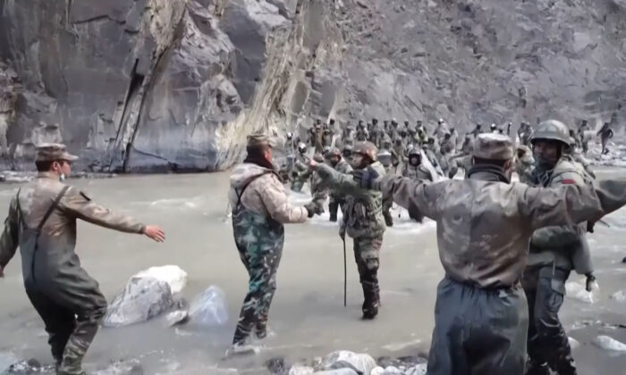This video frame grab taken from footage recorded in mid-June 2020 and released by China Central Television (CCTV) on February 20, 2021, shows Chinese (foreground) and Indian soldiers (R, background) during an incident where troops from both countries clashed in the Line of Actual Control (LAC) in the Galwan Valley, in the Karakoram Mountains in the Himalayas, in June 2020. (AFP Photo/China Central Television)