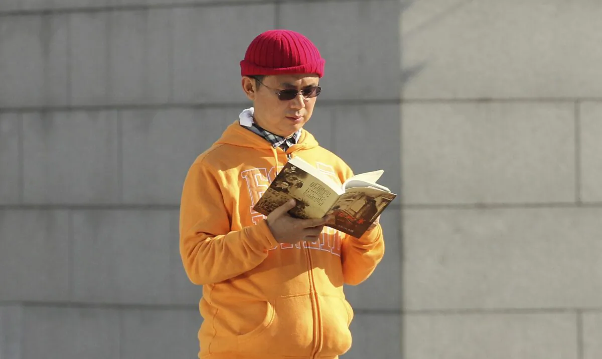 Xiao Jianhua, a Chinese-born Canadian billionaire, reads a book outside the International Finance Center in Hong Kong in December 2013. (Next Magazine/AP Photo)