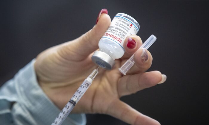 A person draws  Moderna vaccine into a syringe during a drive-through COVID-19 vaccine clinic at St. Lawrence College in Kingston, Ontario, on Jan. 2, 2022. (The Canadian Press/Lars Hagberg)