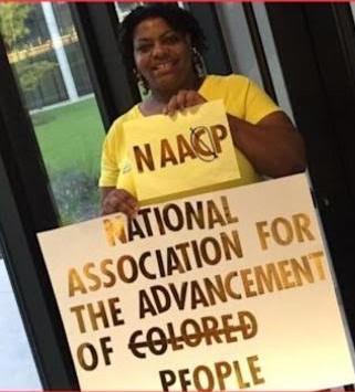 Delia Gray holds her handmade sign, as part of her five-year "one woman crusade" to get the National Association for the Advancement of Colored People to remove the "C" from the organization's name. 