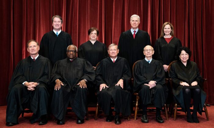 Members of the Supreme Court pose for a group photo at the Supreme Court in Washington, D.C., on April 23, 2021. Seated from left: Justices Samuel Alito and Clarence Thomas, Chief Justice John Roberts, and Justices Stephen Breyer and Sonia Sotomayor. Standing from left: Justices Brett Kavanaugh, Elena Kagan, Neil Gorsuch, and Amy Coney Barrett. (Erin Schaff/Pool/Getty Images)