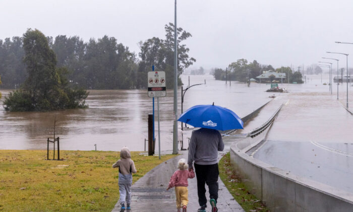 Ludzie oglądają zalany most Windsor bridge wzdłuż rzeki Hawkesbury na przedmieściach Windsor w Sydney w Australii 4 lipca 2022 r. (Jenny Evans/Getty Images)