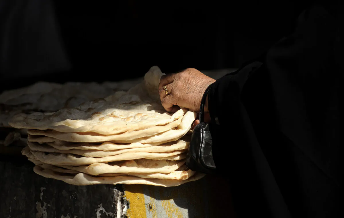 An Iraqi woman buys bread from a bakery in the town of Khanaqin, in Diyala Province, Iran, on Jan. 30, 2009. (Filippo Monteforte/AFP via Getty Images)