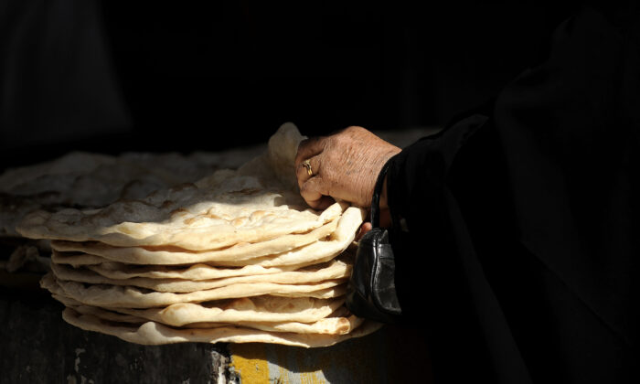 An Iraqi woman buys bread from a bakery in the town of Khanaqin, in Diyala Province, Iran, on Jan. 30, 2009. (Filippo Monteforte/AFP via Getty Images)