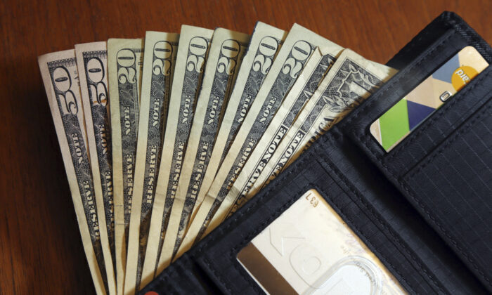 Cash is fanned out from a wallet in this photo illustration taken in North Andover, Mass., on June 15, 2018. (Elise Amendola/AP Photo)