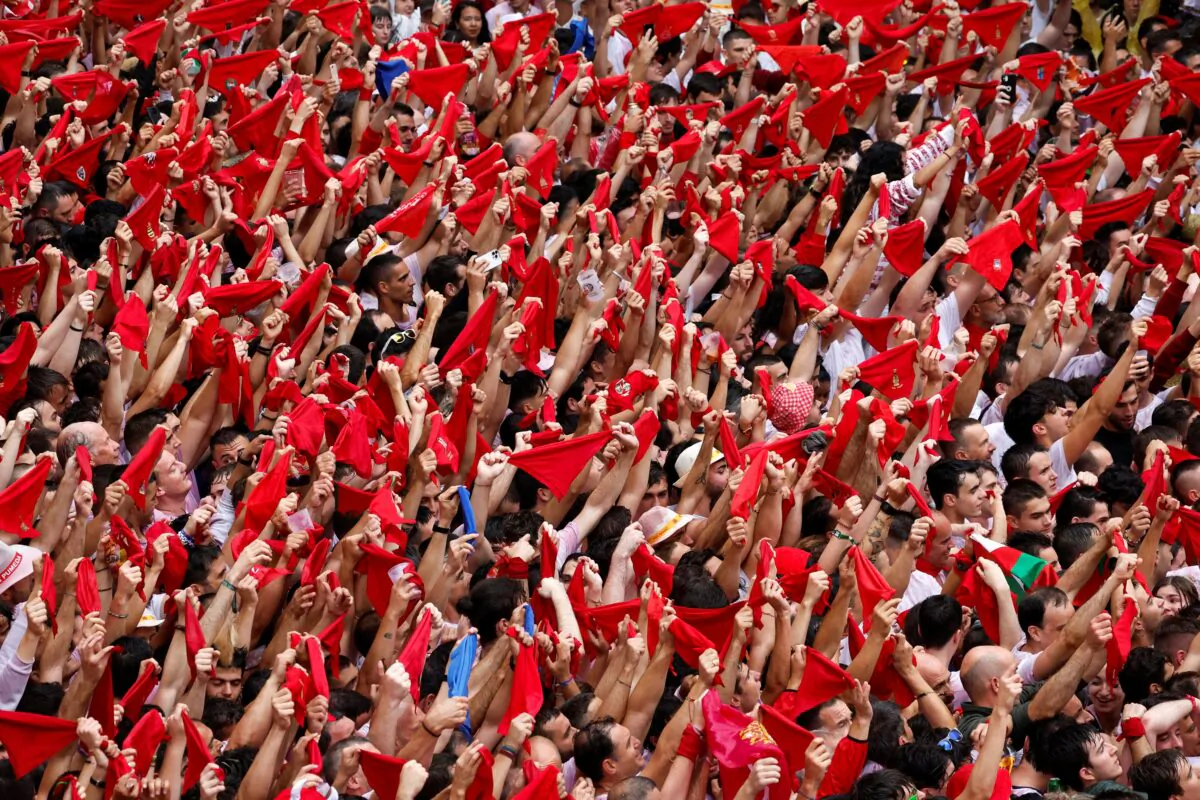 Revelers hold up traditional red scarves during the opening of the San Fermin festival in Pamplona, Spain, on July 6, 2022. (Vincent West/Reuters)