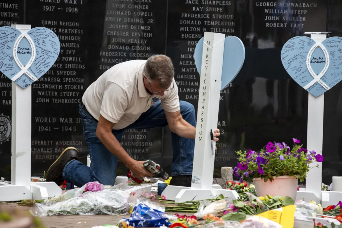 A member of the Lutheran Church Charities assembles a memorial for the victims of a mass shooting at a Fourth of July parade, in Highland Park, Ill., on July 6, 2022 that motivated the passage of the Protecting Illinois Communities Act upheld by the Illinois Supreme Court. (Jim Vondruska/Getty Images)