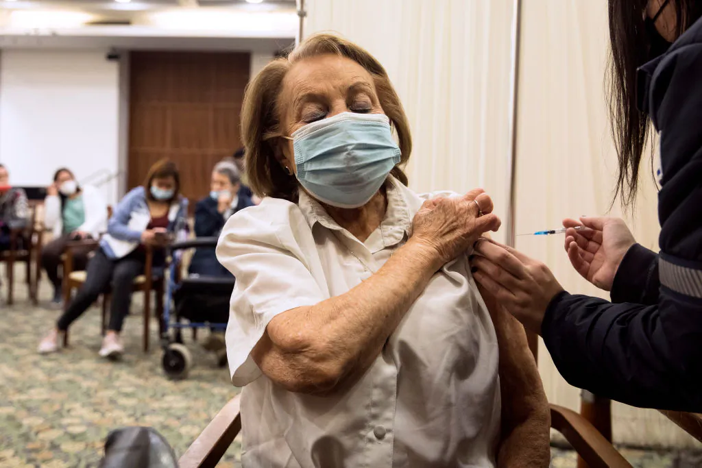 A resident receives a fourth dose of the COVID-19 vaccine at a nursing home after Israel approved it for people older than 60, in Tel Mond, Israel, on Jan. 6, 2022. (Amir Levy/Getty Images)