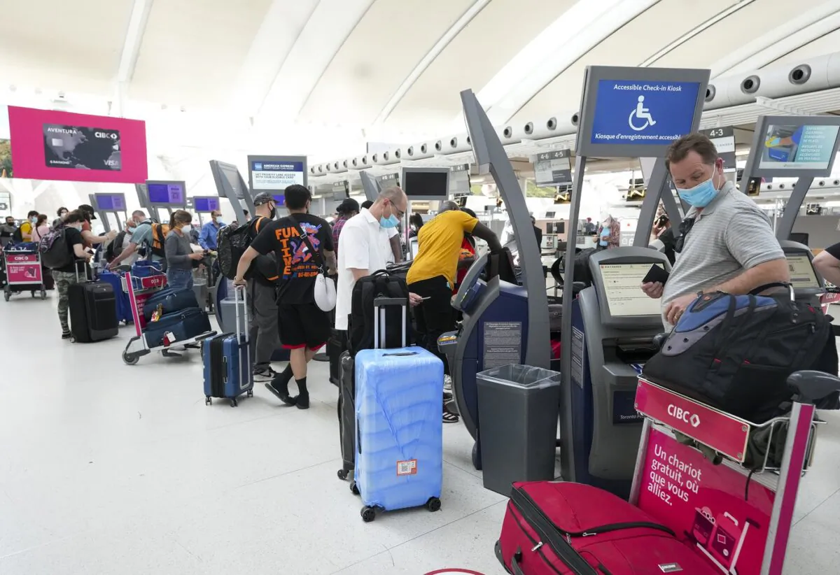 People wait in line to check in at Pearson International Airport in Toronto on May 12, 2022. (The Canadian Press/Nathan Denette)