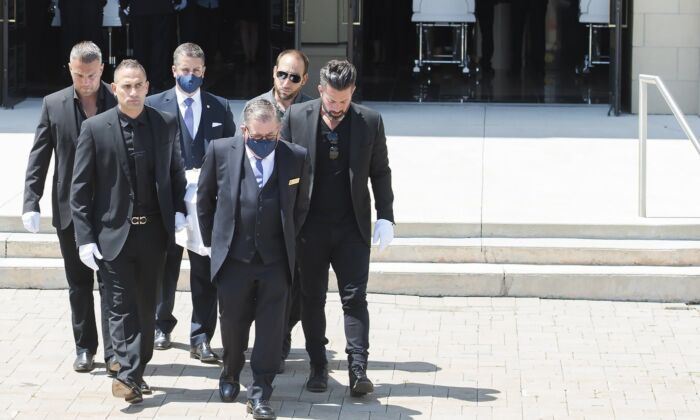 Pallbearers carry the caskets of Karolina Ciasullo and her three young daughters, six year-old Klara Ciasullo, four year-old Lilianna Ciasullo and one year-old Mila Ciasullo, who were killed in a fatal vehicle crash in Brampton, leave the funeral service in Brampton, Ont., on June 25, 2020. (The Canadian Press/Nathan Denette)