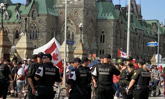 A heavy police presence is seen in Ottawa, Ont., as people headed to the national capital to mark Canada Day on July 1, 2022. A massive rally was held at the Parliament Hill that day following a parade the city's downtown to pretest the federal COVID-19 mandates. (Limin Zhou/The Epoch Times) 