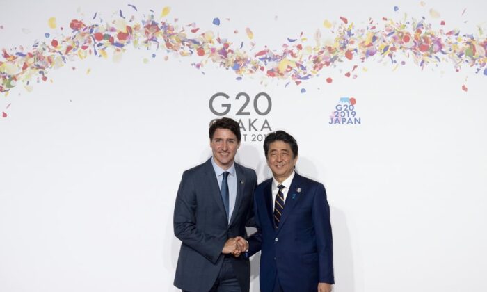 Canadian Prime Minister Justin Trudeau greets then-Japanese Prime Minister Shinzo Abe at the G-20 summit in Osaka, Japan, on June 28, 2019. (AP Photo/Susan Walsh)