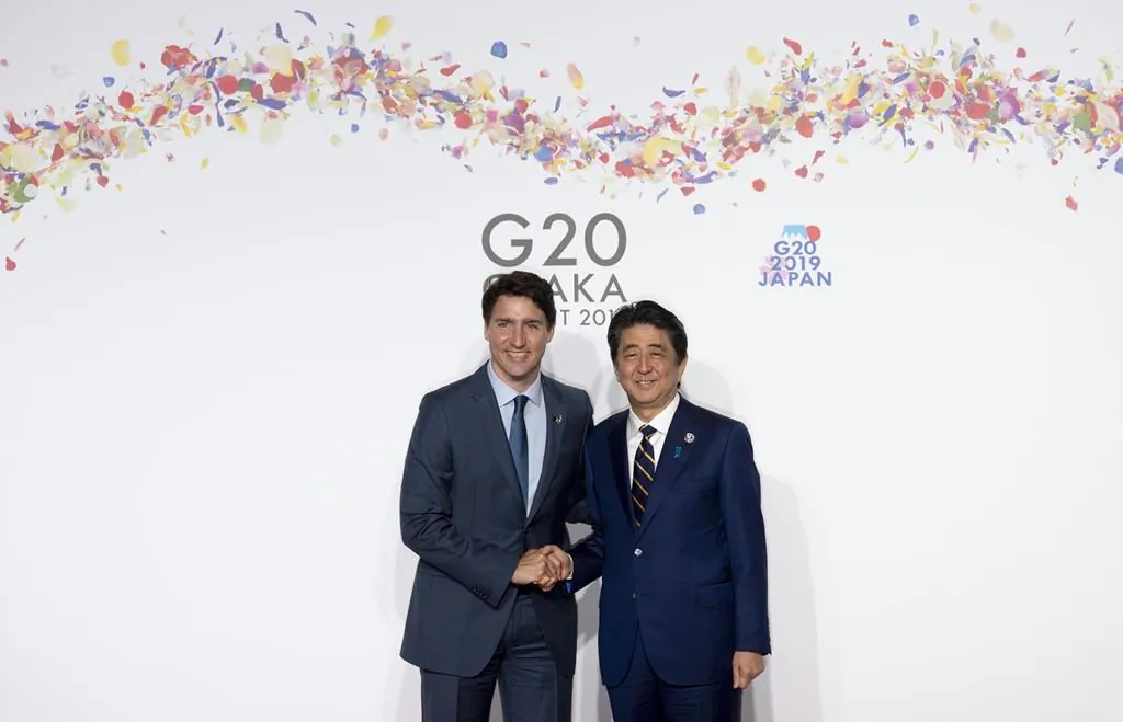 Canadian Prime Minister Justin Trudeau greets then-Japanese Prime Minister Shinzo Abe at the G-20 summit in Osaka, Japan, on June 28, 2019. (AP Photo/Susan Walsh)