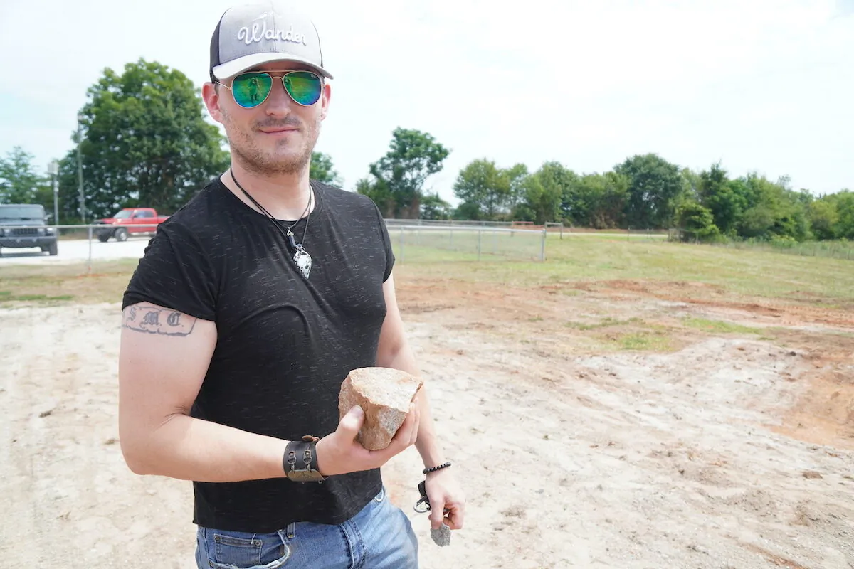 Eric holds a small chunk of rock left over from the destruction of the Georgia Guidestones in Elberton, Georgia on July 8, 2022. (Jackson Elliott/The Epoch Times)