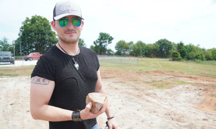 Eric holds a small chunk of rock left over from the destruction of the Georgia Guidestones in Elberton, Georgia on July 8, 2022. (Jackson Elliott/The Epoch Times) 