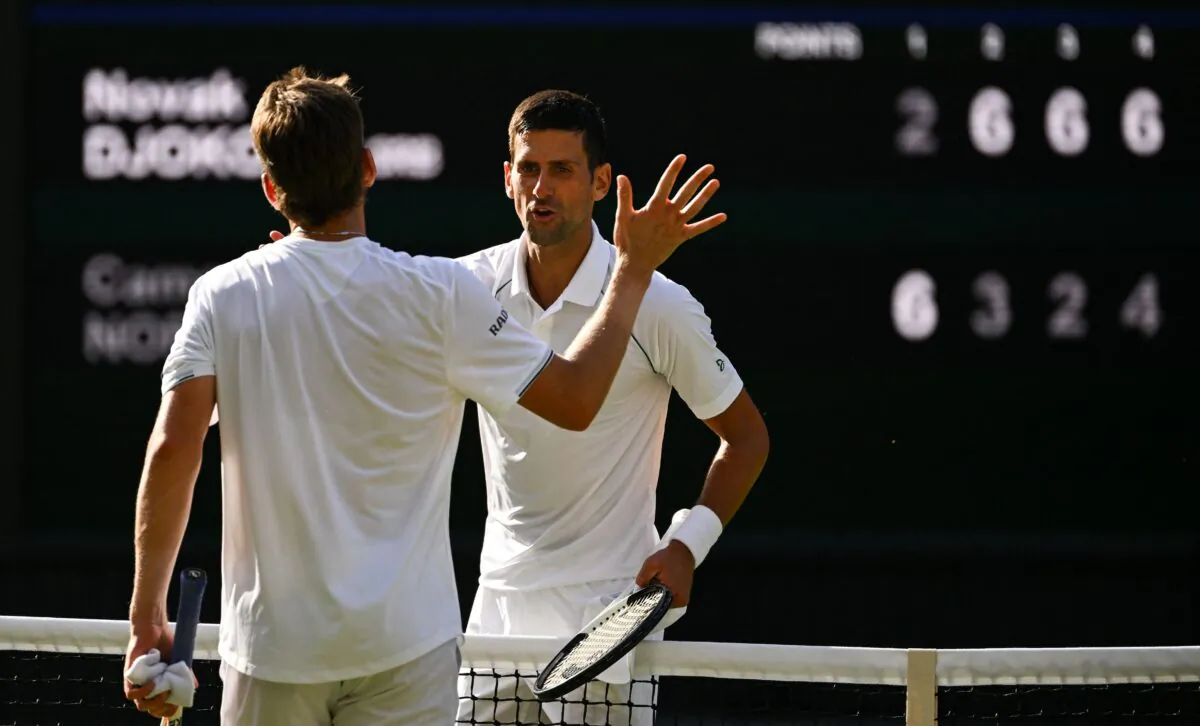 Serbia's Novak Djokovic (R) shakes hands with Britain's Cameron Norrie after winning their men's singles semifinal tennis match on the twelfth day of the 2022 Wimbledon Championships at The All England Tennis Club in Wimbledon, southwest London, on July 8, 2022. (Sebastien Bozon/AFP via Getty Images)
