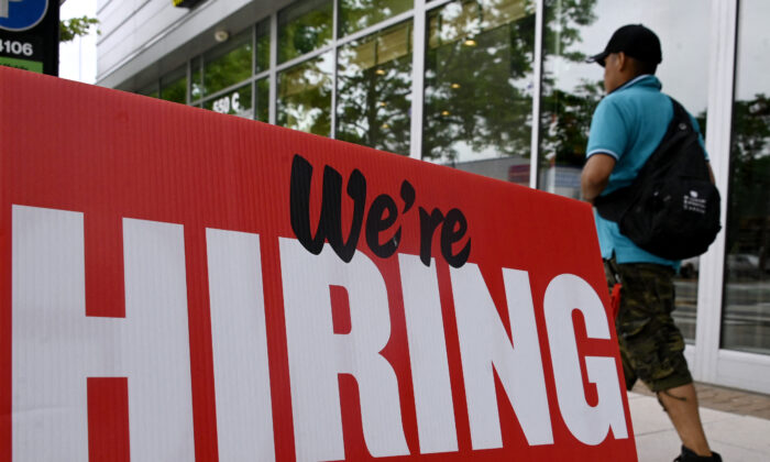 A man walks past a "now hiring" sign posted outside of a restaurant in Arlington, Va., on June 3, 2022. (Olivier Douliery/AFP via Getty Images)