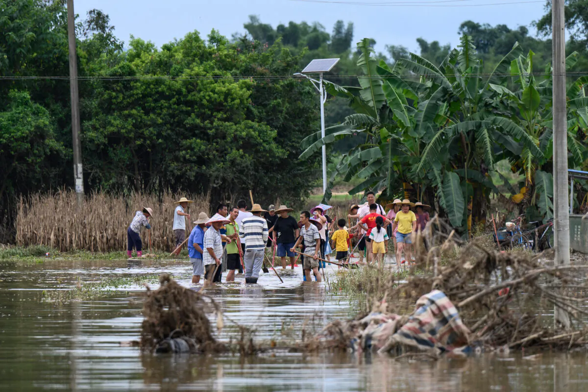 Residents clear a flooded street after heavy rains caused by typhoon Chaba, in Yingde, Qingyuan city, in China's southern Guangdong province on July 6, 2022. (STR/AFP via Getty Images)