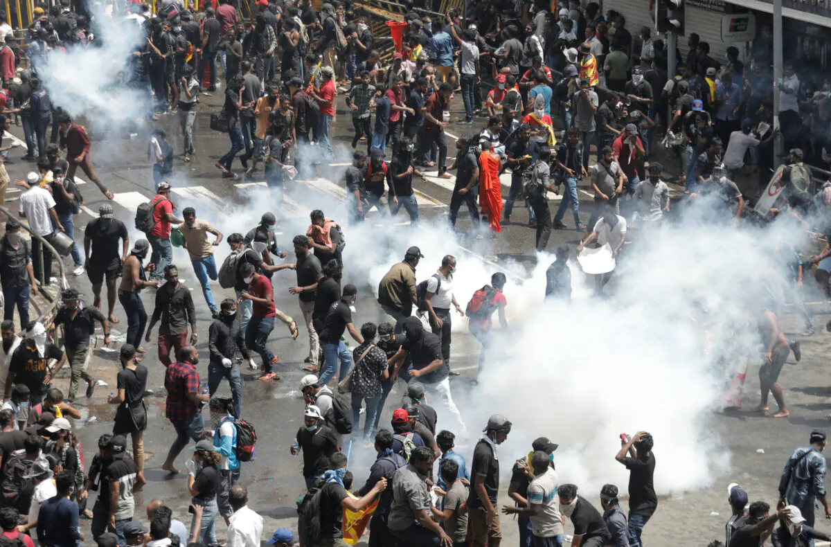 Demonstrators run from tear gas used by police during a protest demanding the resignation of President Gotabaya Rajapaksa, amid the country's economic crisis, near the president's residence in Colombo, Sri Lanka, on July 9, 2022. (Dinuka Liyanawatte/Reuters)