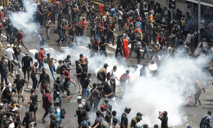 Demonstranci uciekają przed gazem łzawiącym użytym przez policję podczas protestu domagającego się dymisji prezydenta Gotabaya Rajapaksy, w obliczu kryzysu gospodarczego w kraju, w pobliżu rezydencji prezydenta w Kolombo na Sri Lance, 9 lipca 2022 r. (Dinuka Liyanawatte/Reuters)