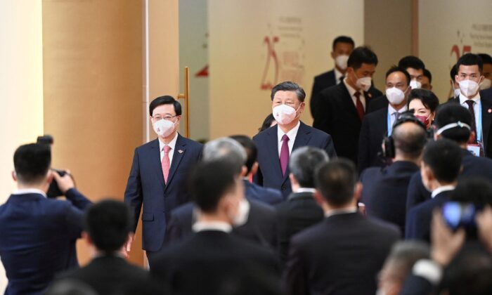 2022 年 7 月 1 日，中共领导人习近平（中）与即将上任的香港行政长官李约翰（面向左）一同抵达香港，出席李的宣誓就职仪式，并于 2022 年 7 月 1 日在香港为香港新政府就职。（Selim Chtayti/POOL/AFP via Getty图片）