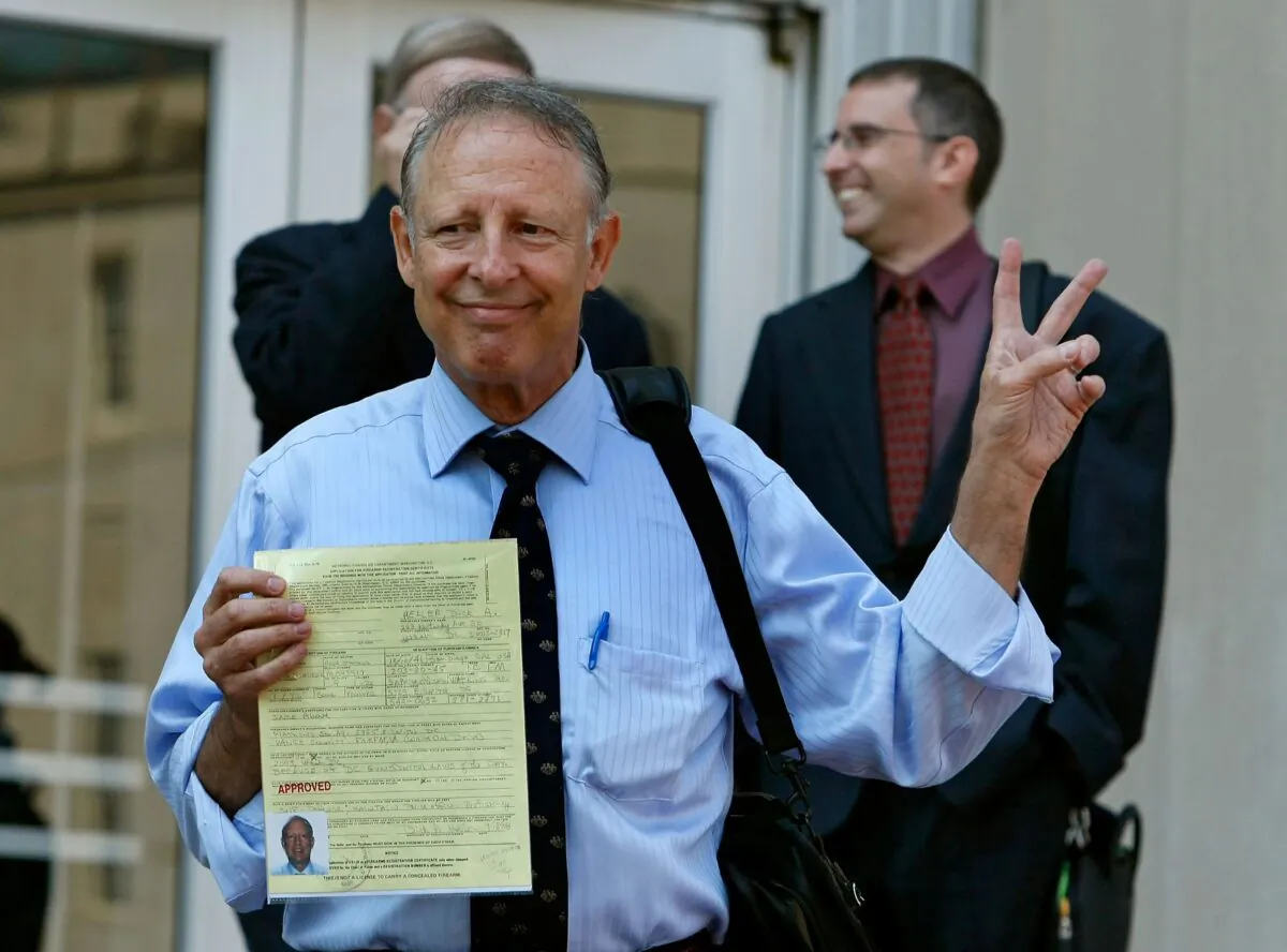 Dick Heller, plaintiff in the Supreme Court case District of Columbia v. Heller, gestures while holding his newly approved gun permit at the District of Columbia Police Department, Aug. 18, 2008, in Washington. (Mark Wilson/Getty Images)