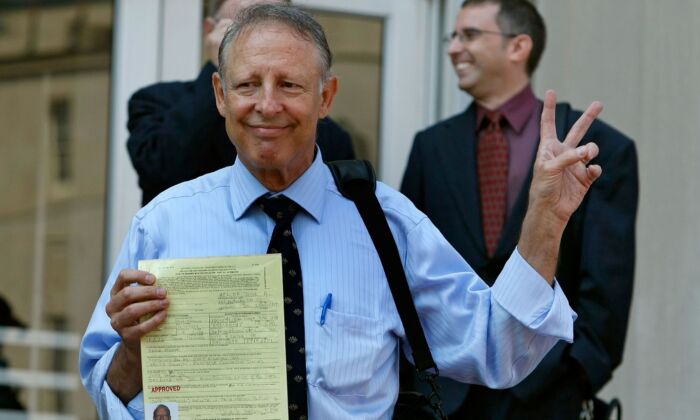 Dick Heller, plaintiff in the Supreme Court case Heller v. District of Columbia, gestures while holding his newly approved gun permit at the District of Columbia Police Department, in Washington, on Aug. 18, 2008. (Mark Wilson/Getty Images)