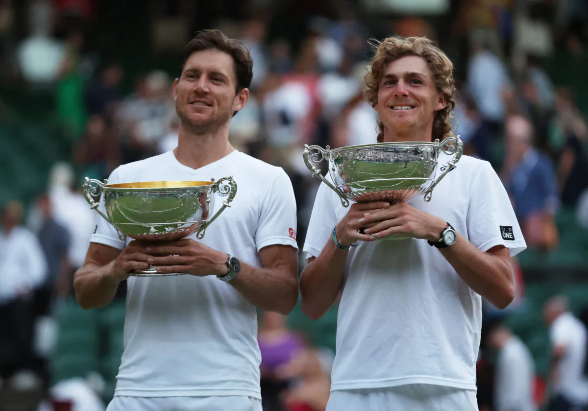 Australia's Matthew Ebden (L) and Max Purcell (R) celebrate with the trophy after winning against Croatia's Nikola Mektic and Mate Pavic in their men's doubles final tennis match at the 2022 Wimbledon Championships in London on July 9, 2022. (Matthew Childs/Reuters)