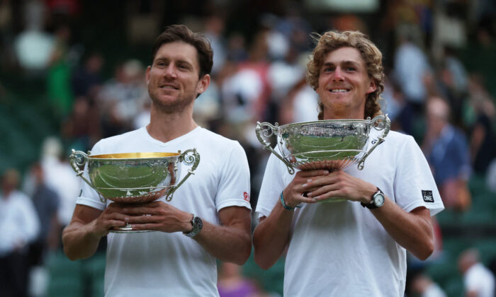 Australia's Matthew Ebden (L) and Max Purcell (R) celebrate with the trophy after winning against Croatia's Nikola Mektic and Mate Pavic in their men's doubles final tennis match at the 2022 Wimbledon Championships in London on July 9, 2022. (Matthew Childs/Reuters)