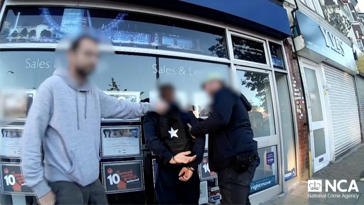 Police officers arrest a suspected gang member in London on July 5, 2022, in a still from video. (NCA via Reuters/Screenshot via The Epoch Times)