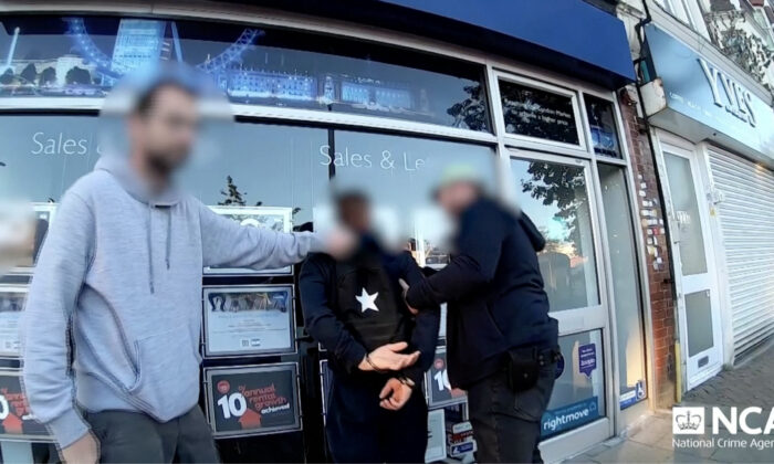 Police officers arrest a suspected gang member in London on July 5, 2022, in a still from video. (NCA via Reuters/Screenshot via The Epoch Times)