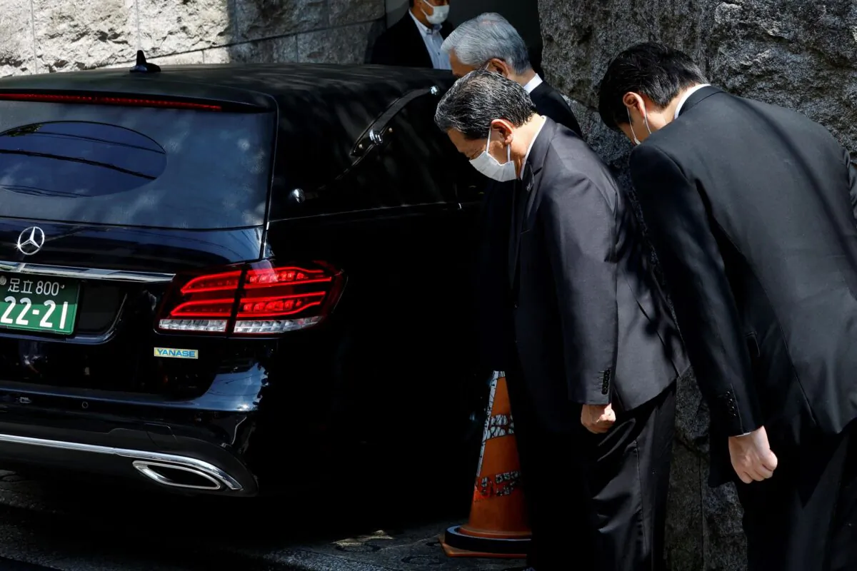 LDP officials pray to the vehicle believed to be carrying the body of former Japanese Prime Minister Shinzo Abe, who was shot while campaigning for a parliamentary election, at his residence in Tokyo, Japan, on July 9, 2022. (Kim Kyung-Hoon/Reuters)