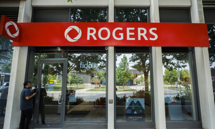 A man stands outside a locked Rogers wireless store in Toronto amid a country wide outage of the telecommunication company's services, on July 8, 2022. (The Canadian Press/Cole Burston)