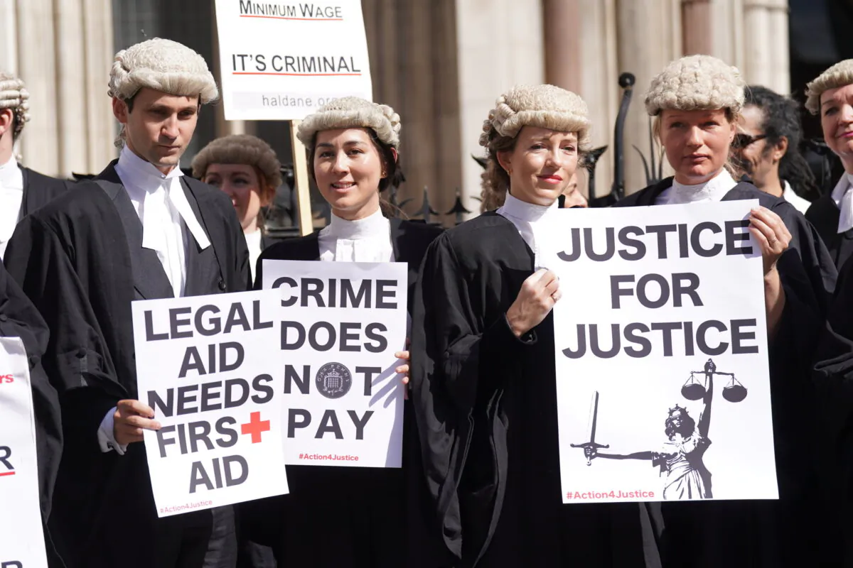 Criminal defence barristers gather outside the Royal Courts of Justice in London to support the ongoing Criminal Bar Association action over government-set fees for legal aid advocacy work, in an undated file photo. (Kirsty O’Connor/PA)