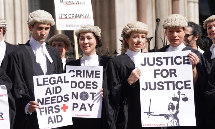 Criminal defence barristers gather outside the Royal Courts of Justice in London to support the ongoing Criminal Bar Association action over government-set fees for legal aid advocacy work, in an undated file photo. (Kirsty O’Connor/PA)