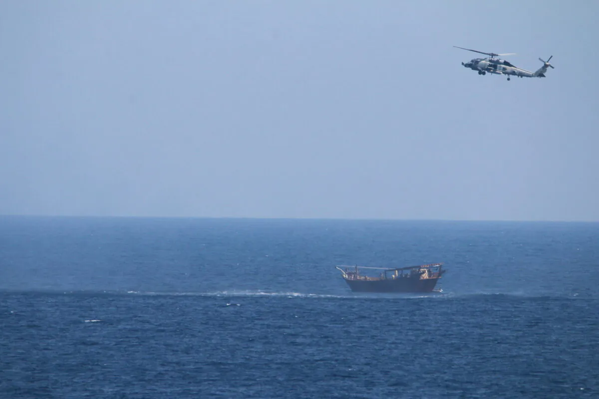 A Navy Seahawk helicopter flies over a stateless dhow later found to be carrying a hidden arms shipment in the Arabian Sea on May 6, 2021. (U.S. Navy via AP)