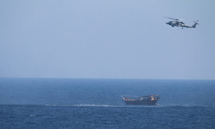 A Navy Seahawk helicopter flies over a stateless dhow later found to be carrying a hidden arms shipment in the Arabian Sea on May 6, 2021. (U.S. Navy via AP)