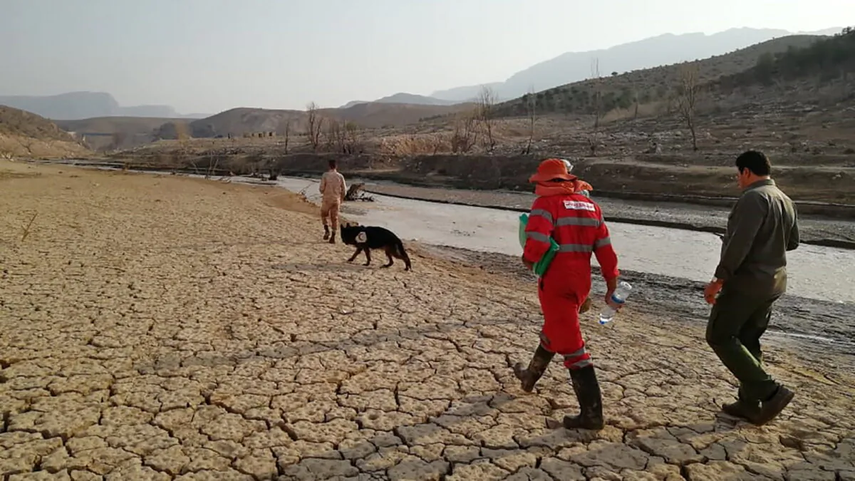 Members of a rescue team search for missing people of Friday's flash floods in Iran's drought-stricken southern Fars Province, Iran, on July 23, 2022. (Iranian Red Crescent Society via AP)