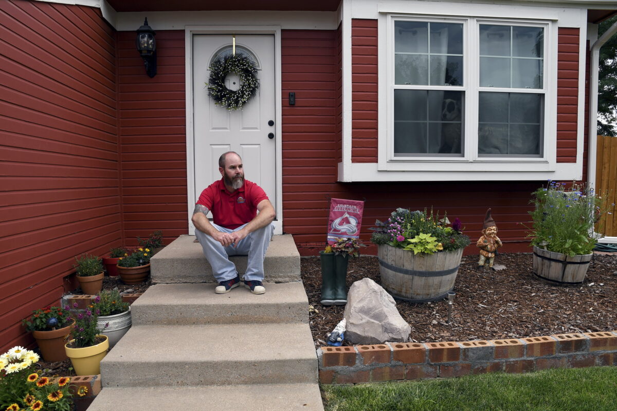 Kyle Tomcak sits in front of his house in Aurora, Colo., on July 18, 2022. (Thomas Peipert/AP Photo)
