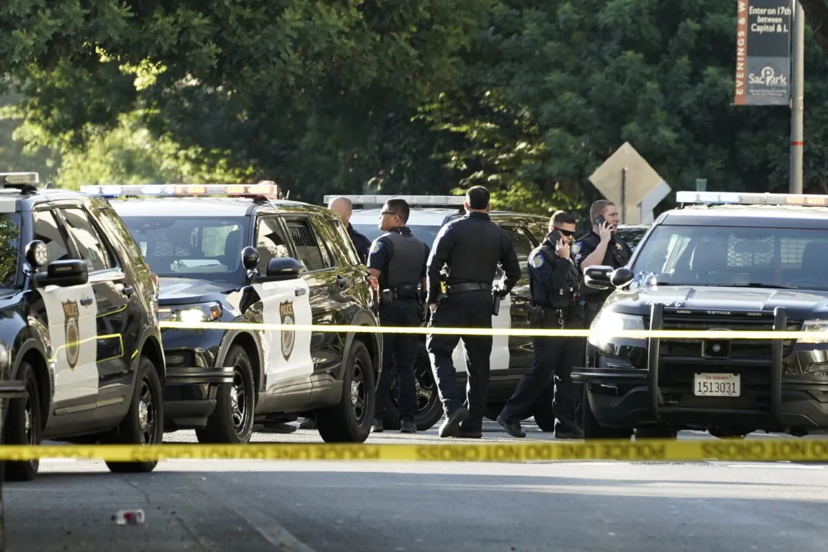 Sacramento police officers gather near the scene of the shooting outside a nightclub in downtown Sacramento, Calif., in the early morning hours on July 4, 2022. (Rich Pedroncelli/AP Photo)