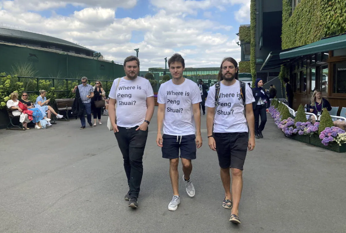 Protesters Will Hoyles, 39 (L), Caleb Compton, 27 (C), and Jason Leith, 34, who all work for Free Tibet, pose for the media in T-shirts reading "Where is Peng Shuai" at the Wimbledon Tennis tournament in London on July 4, 2022. (Rebecca Speare-Cole/PA via AP)