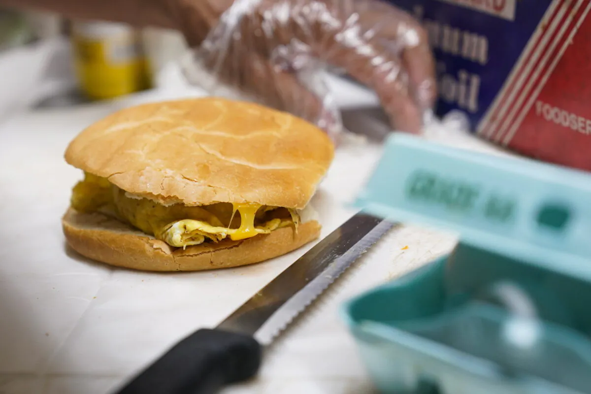 Hector Perez prepares to wrap a bacon, egg and cheese sandwich at a bodega in the Bronx section of New York, on July 22, 2022. (Seth Wenig/AP Photo)